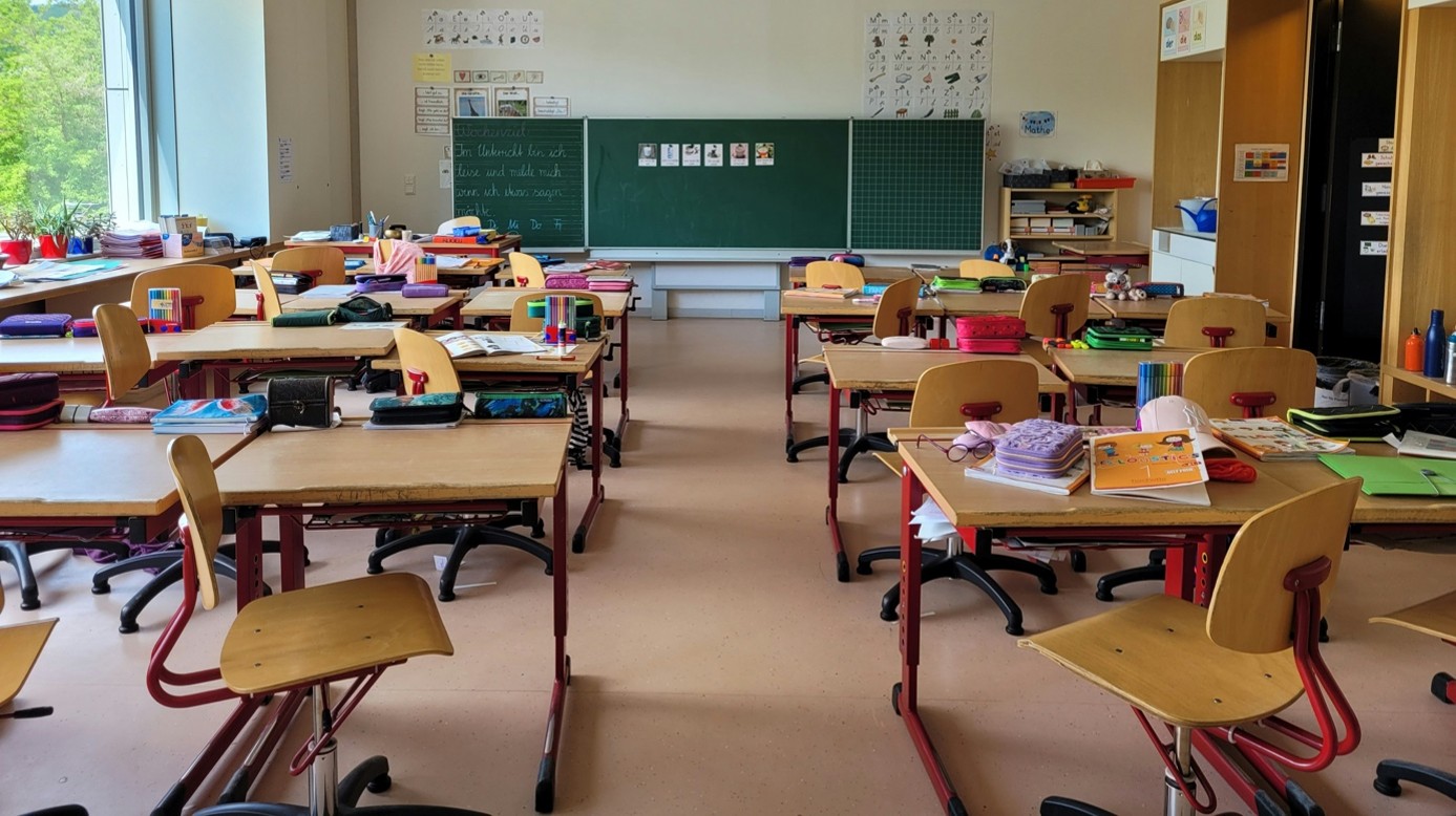 Ein Klassenzimmer mit vielen Tischen und Stühlen.